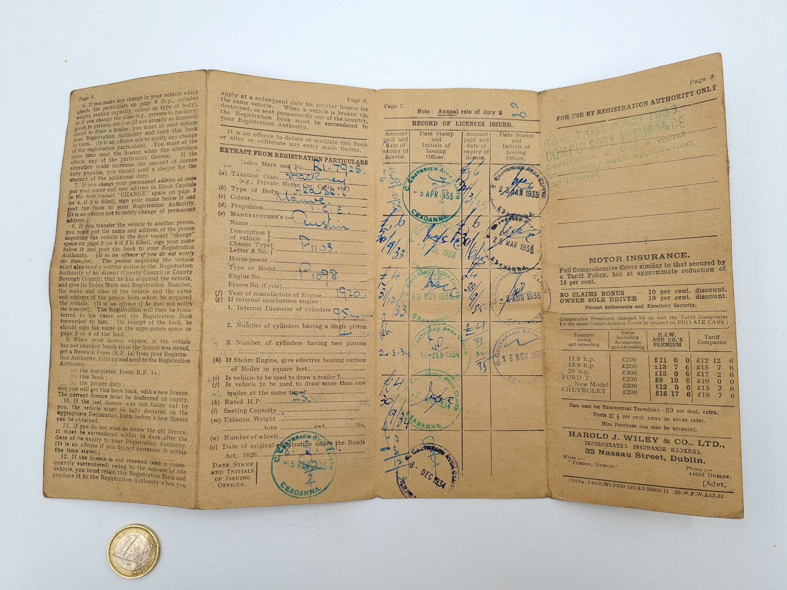 A vintage motor insurance receipt card with a gold coin in the foreground.