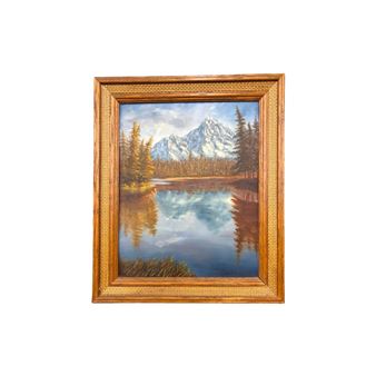 A mountain looming in the background behind a calm mountain lake surrounded by a thick conifer forest - Miklós‏ Gáspár