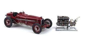 A detailed model of a vintage red race car displayed alongside its engine.