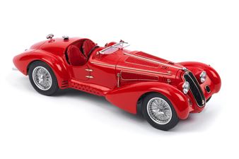 A glossy red vintage sports car model displayed against a stark white background.