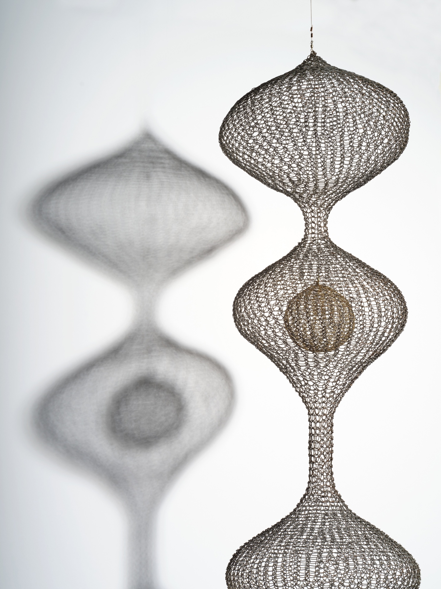 Artwork by Ruth Asawa, Untitled (S.467, Hanging Four-Lobed Continuous Form with a Sphere in the Second Lobe), Made of oxidized copper and brass wire