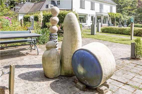 A group of abstract stone sculptures arranged in a park setting.
