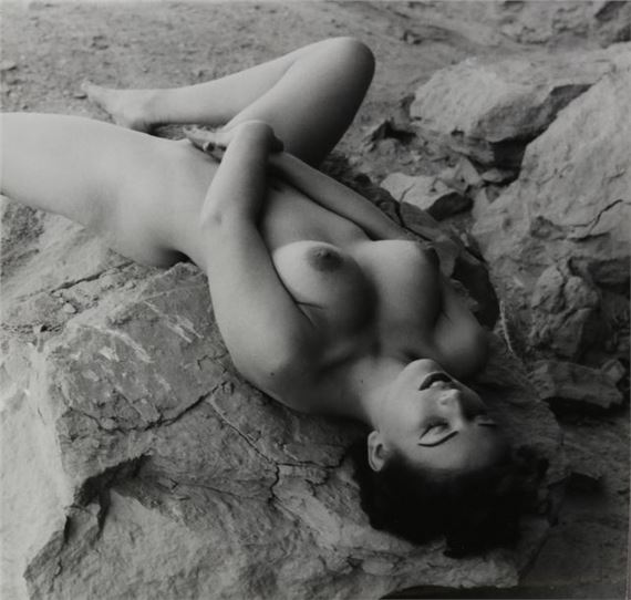 Nude woman lying on a rock by Andre de Dienes, circa 1960