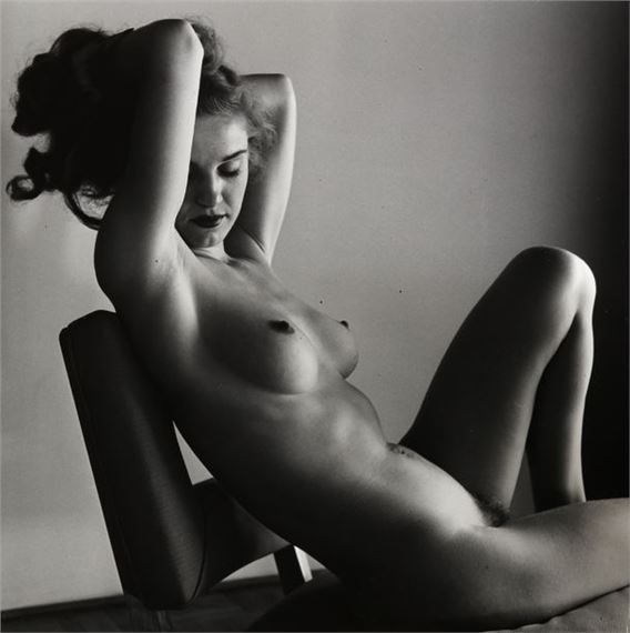 Nude woman sitting on a chair by Andre de Dienes, circa 1960