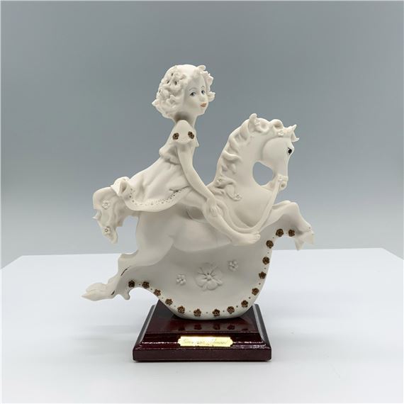 Fine crafted resin with white matte finish captures a young girl riding a detailed rocking horse