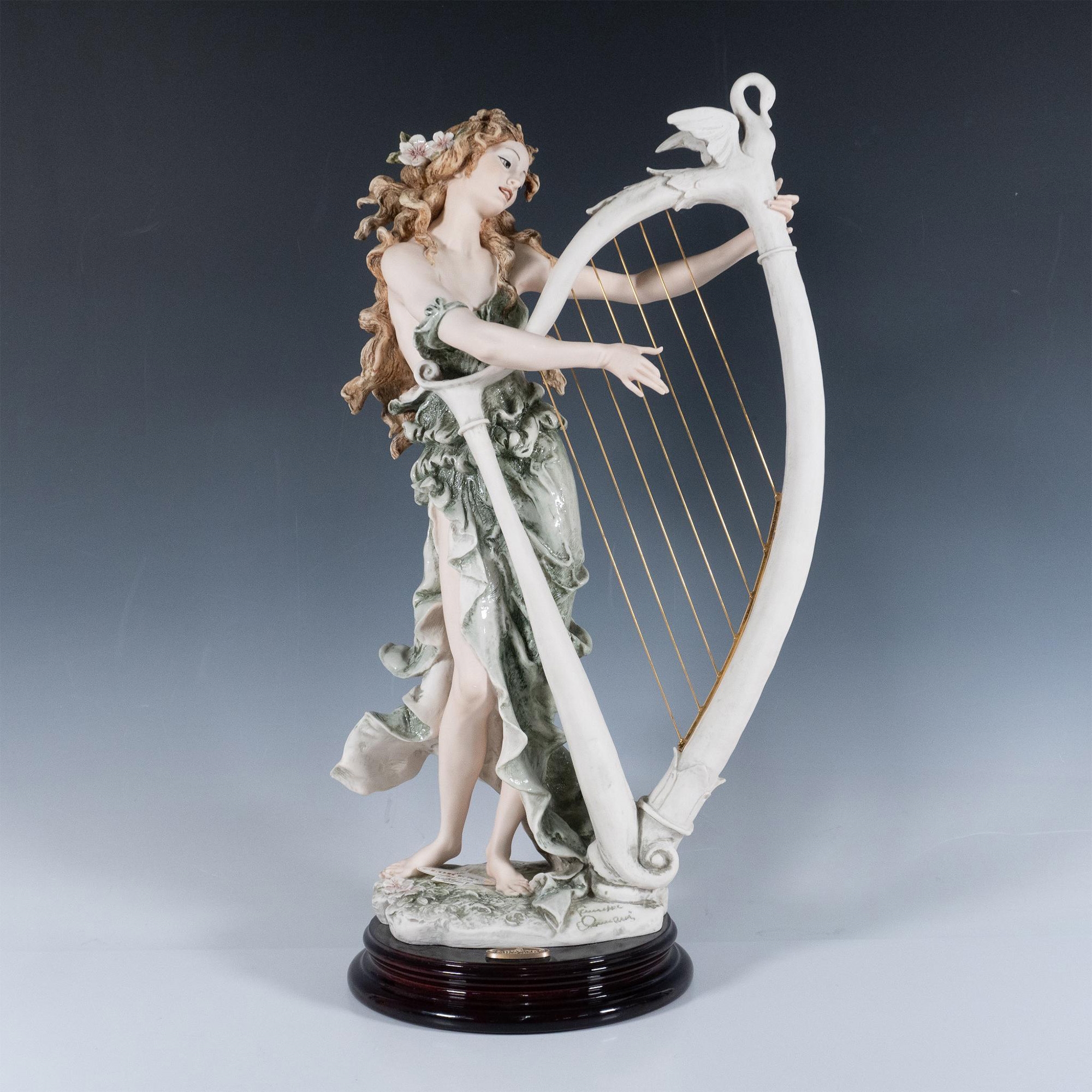 Artwork by Giuseppe Armani, Resin sculpture of a graceful woman playing a large lyre, Made of Resin sculpture