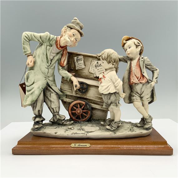Fine crafted resin captures a charming scene of an elderly street organ player interacting with two curious children