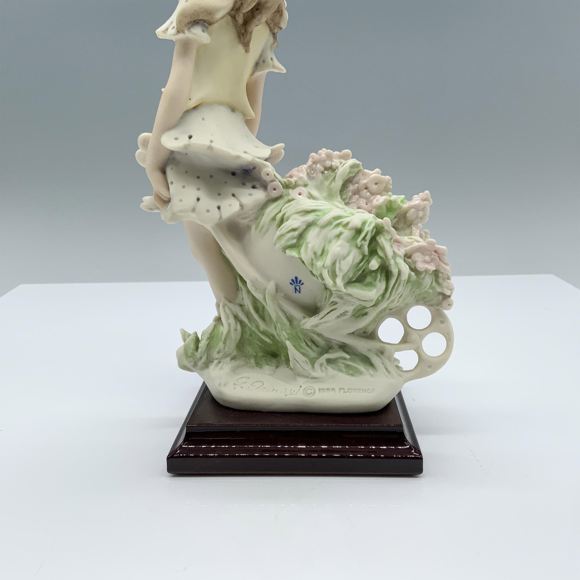 Artwork by Giuseppe Armani, Fine crafted resin with white matte finish captures a young girl carrying a cart full of flowers, Made of resin with white matte
