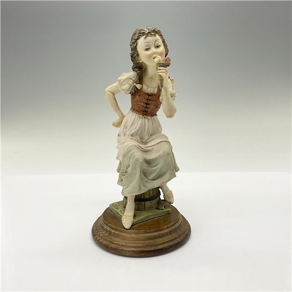 This adorable resin figurine depicts a seated girl eating ice cream