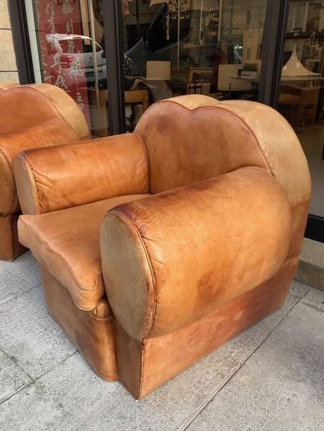 Artwork by Rene Drouet, René DROUET (1898-1993), Vers 1940 Paire de larges fauteuils club de forme cubique, à dossier à découpe mouvementés et accotoirs pleins circulaires, entièrement recouverts d'un cuir gold, Made of brown leather and black metal base