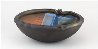 JOHN HIGGINS (born 1947); a high fired earthenware bowl with altered rim covered in black slip and various underglaze - John Higgins