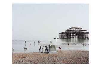 A desolate beach scene featuring a skeletal pier structure and numerous figures wading in the calm sea.