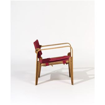 Fauteuil en contreplaqué courbé plaqué de chêne, dossier mobile et assise sanglée tendus de toile rouge. Edition La Crémaillère. - André Renou