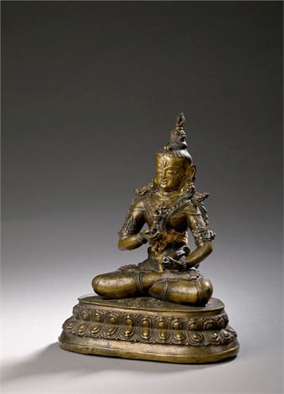 TIBET, 14th century Statuette in repoussé copper alloy representing Vajradhara seated in vajraparyankasana, one hand holding the vajra and the other the ghanta (bell), adorned with numerous jewels (necklaces, earrings, bracelets), the urna prominent, high bun/usnisa surmounted by a vajra and hair loose on the shoulders and back, assembled (by three tenons and mortises) to a base with two rows of lotus petals, traces of cold gold and polychromy on the face and neck, two turquoise inlays and the o by Tibetan School, 14th Century, 14th century