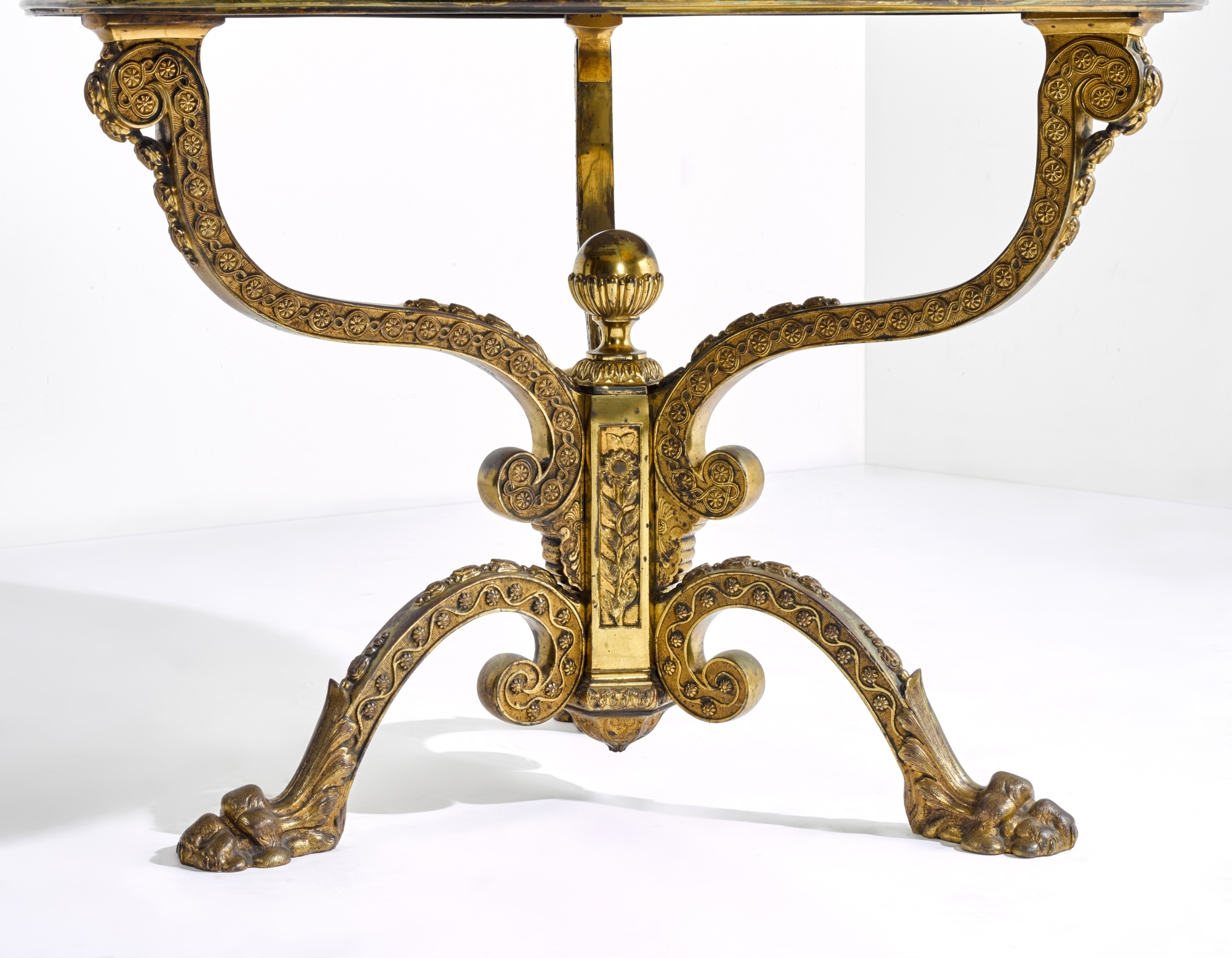 Artwork by Thomas Woodruff, A Victorian gilt-brass mounted Blue John centre table, , the top attributed to Thomas Woodruff, the base by William Tonks and Sons, Made of gilt-brass, the circular Blue John veneered top applied in segments to form concentric rings, the frieze with a border of paterae filled guilloche headed by fluting and stop-fluting, the three similarly cast scrolled supports decorated with husks and converging on a hexagonal pillar with a gadrooned ball finial and decorated on each facet with sunflowers, the arched tripod base similarly decorated with husks and trailing flowers on leafy paw feet