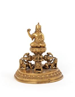 NEPAL, 19th century Gilded bronze group depicting Padmasambhaya seated on a lotus bud base resting on a quadruple vajra and four squatting brides, all resting on a circular base decorated with lotus petals in repoussé on the rim - Nepalese School, 19th Century