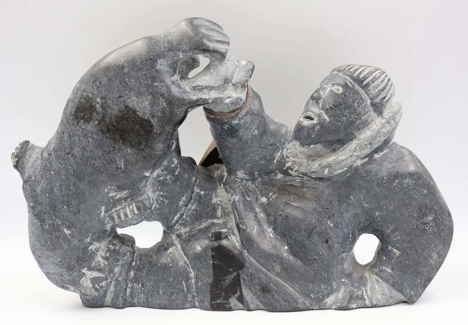 Artwork by Jimmy Muckpah, A hunter struggling with a seal, Made of grey soapstone