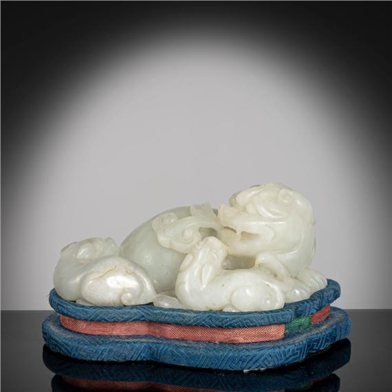 A JADE CARVING OF A FO-LION WITH TWO CUBS by Chinese School
