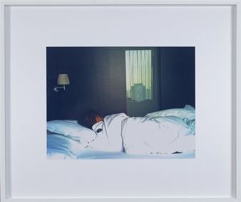 A framed photograph of a person sleeping in a dimly lit bedroom.