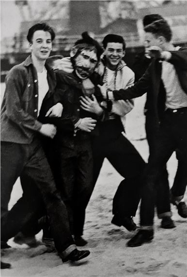 MASKED BOY WITH FRIENDS by Diane Arbus, March 14
