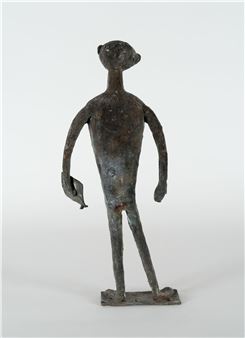 A bronze sculpture of a stylized human figure holding a leaf.