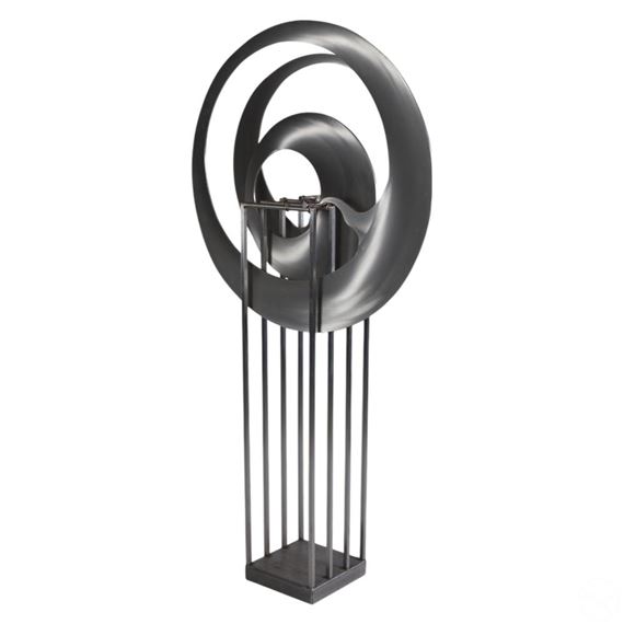 A minimalist sculpture featuring a dark, metallic spiral form mounted on a slender vertical stand.