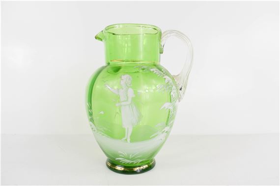 A Victorian green glass Mary Gregory decorated jug by Mary Gregory