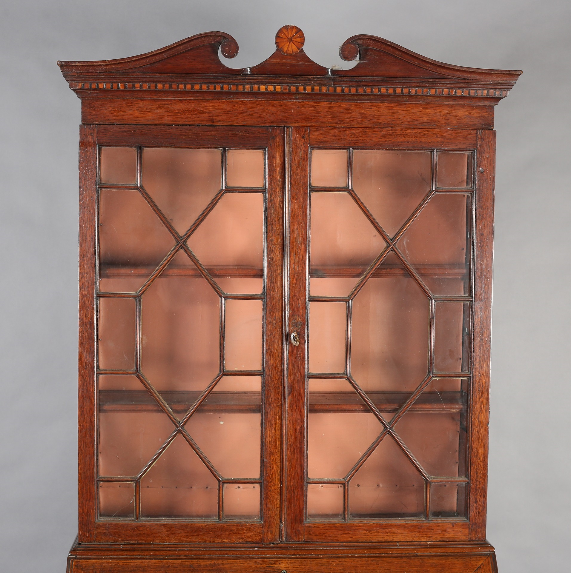 Front | AN EARLYTH CENTURY OAK BUREAU-BOOKCASE, having a break arch ...
