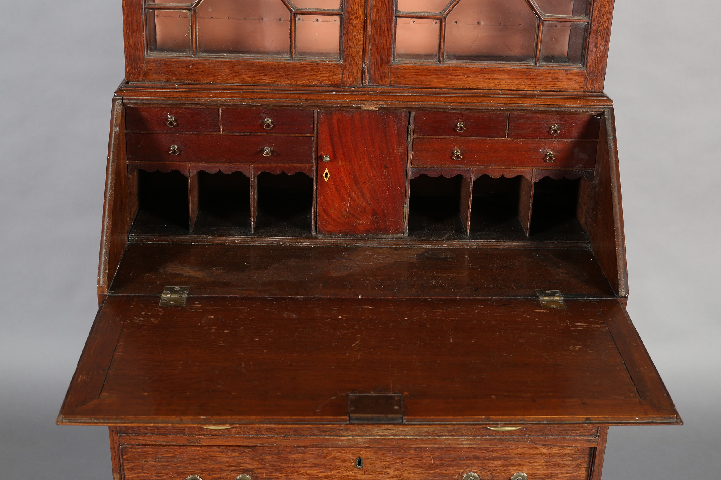 Front | AN EARLYTH CENTURY OAK BUREAU-BOOKCASE, having a break arch ...