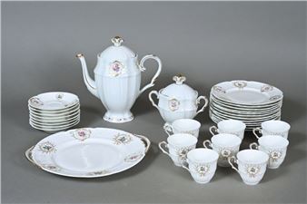 Partie de service en porcelaine de Georges Boyer à Limoges à décor de treillage en semi-relief et de branchages fleuris dans des réserves feuillagées et rubanées comprenant une théière, un sucrier couvert, 8 tasses, 8 sous-tasses, 12 assiettes à dessert et un plat circulaire - Georges Boyer