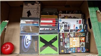 A crate of music CDs featuring artists such as Genesis and Ed Sheeran, along with PlayStation video games - Ed Sheeran