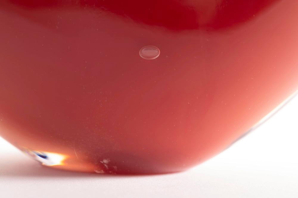 Artwork by Steve Funk, Vase, Made of iron red blown glass with black and white stylized rosettes on front of flattened body