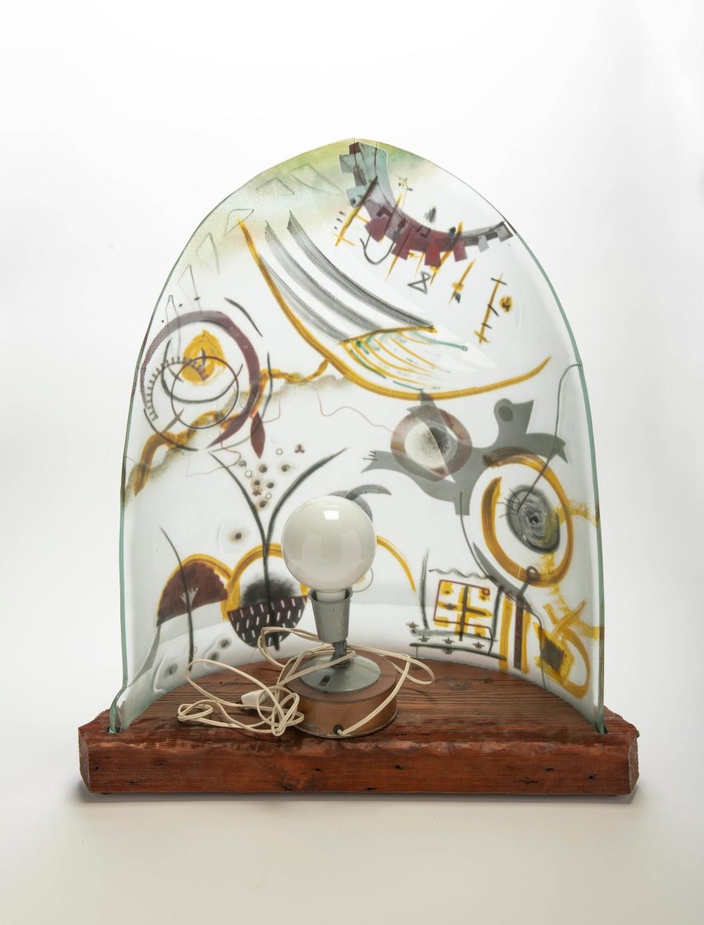 Artwork by Peter Mangan, Lamp, Made of glass with multi colored abstract inclusions designs, upon a wood base with metal fittings