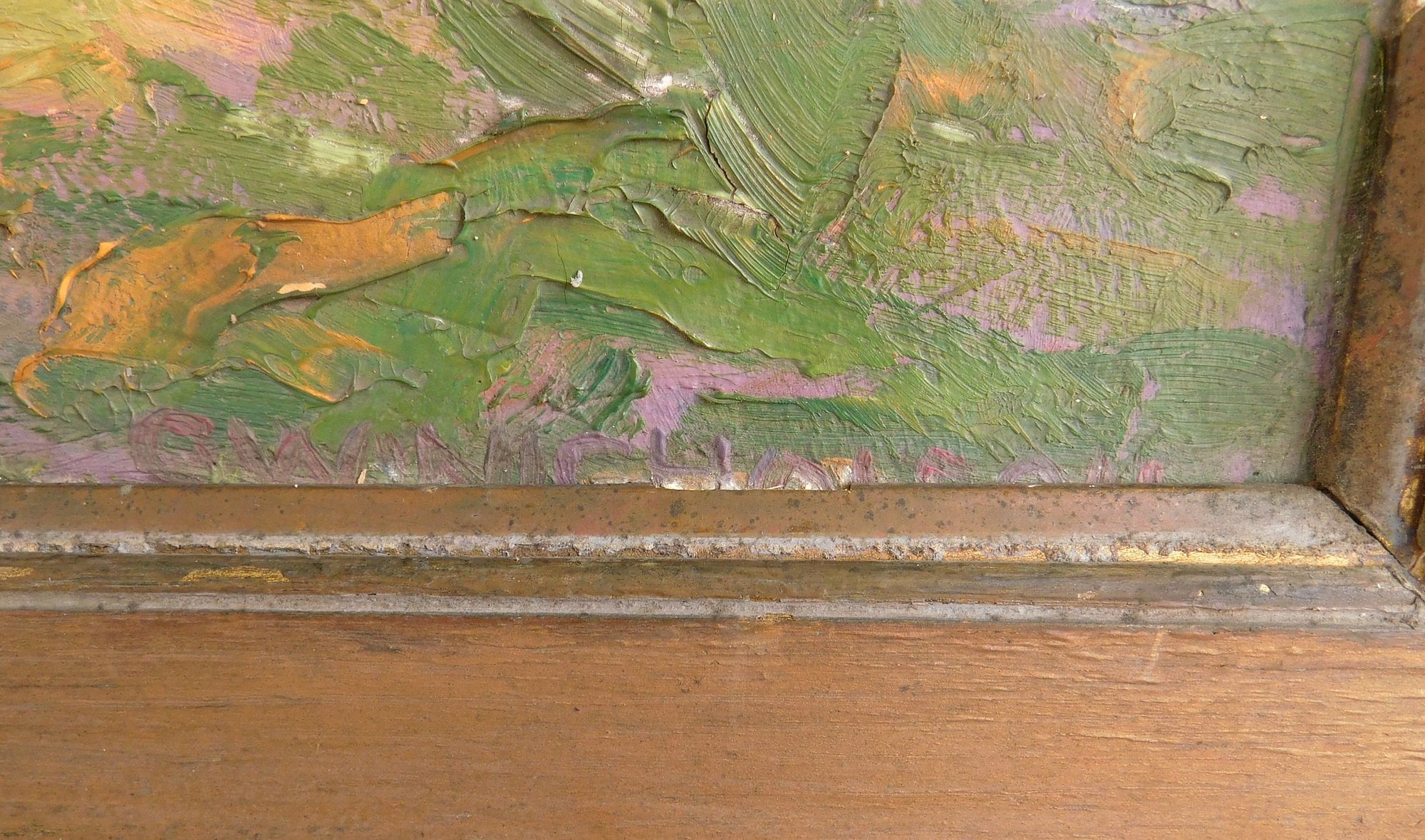 A framed landscape painting of a sunlit path winding through green trees.