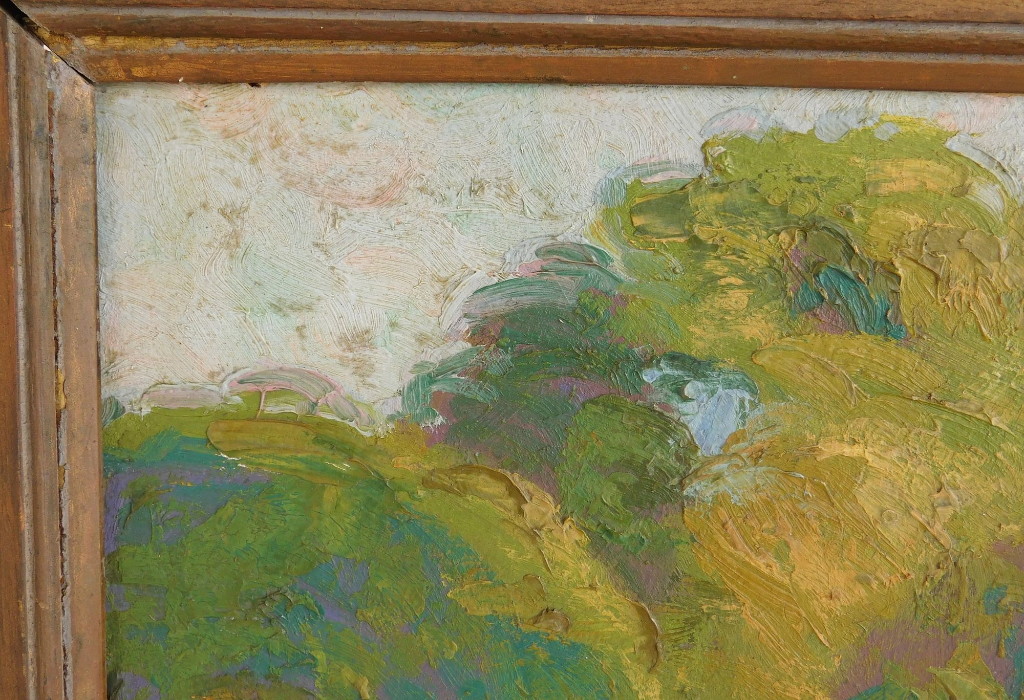 A framed landscape painting of a sunlit path winding through green trees.