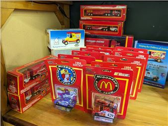A colorful display of boxed toy vehicles arranged on a wooden shelf.