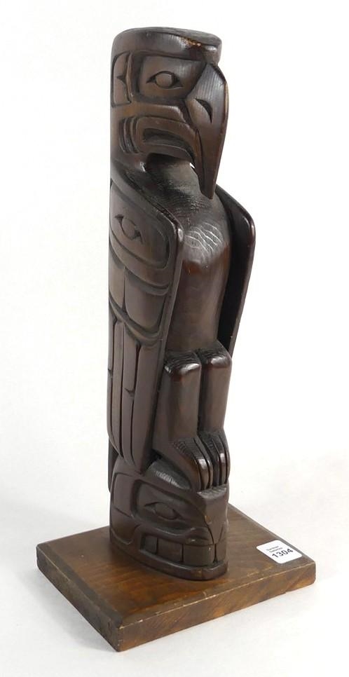 Artwork by Danny Matilpi, A carved wood totem pole with raven, Made of carved wood