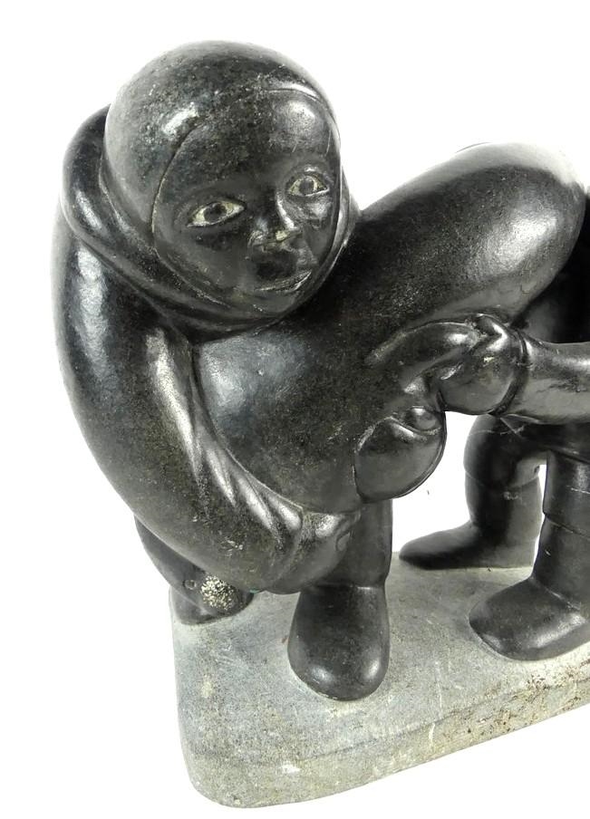 Artwork by Markusi Kuanana, A large-scale soapstone figural group carved in the form of two Inuit hunters holding seal, Made of soapstone