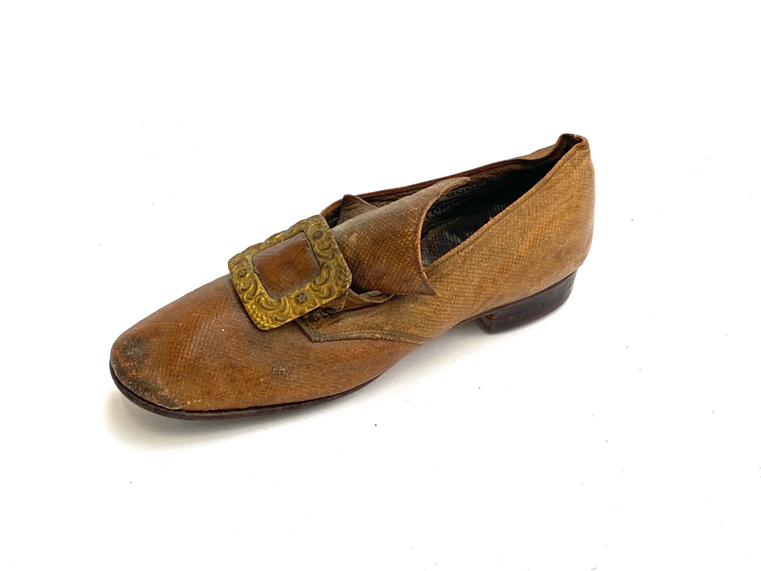 Artwork by Gooch, A lateth century  child's shoe c with  repousse buckle, bears label for John Gooch Brompton Rd, Made of gilt metal