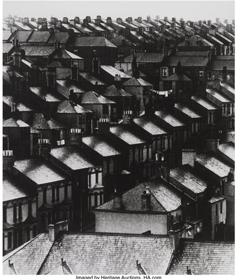 A high-contrast black and white view of a dense urban neighborhood from above.
