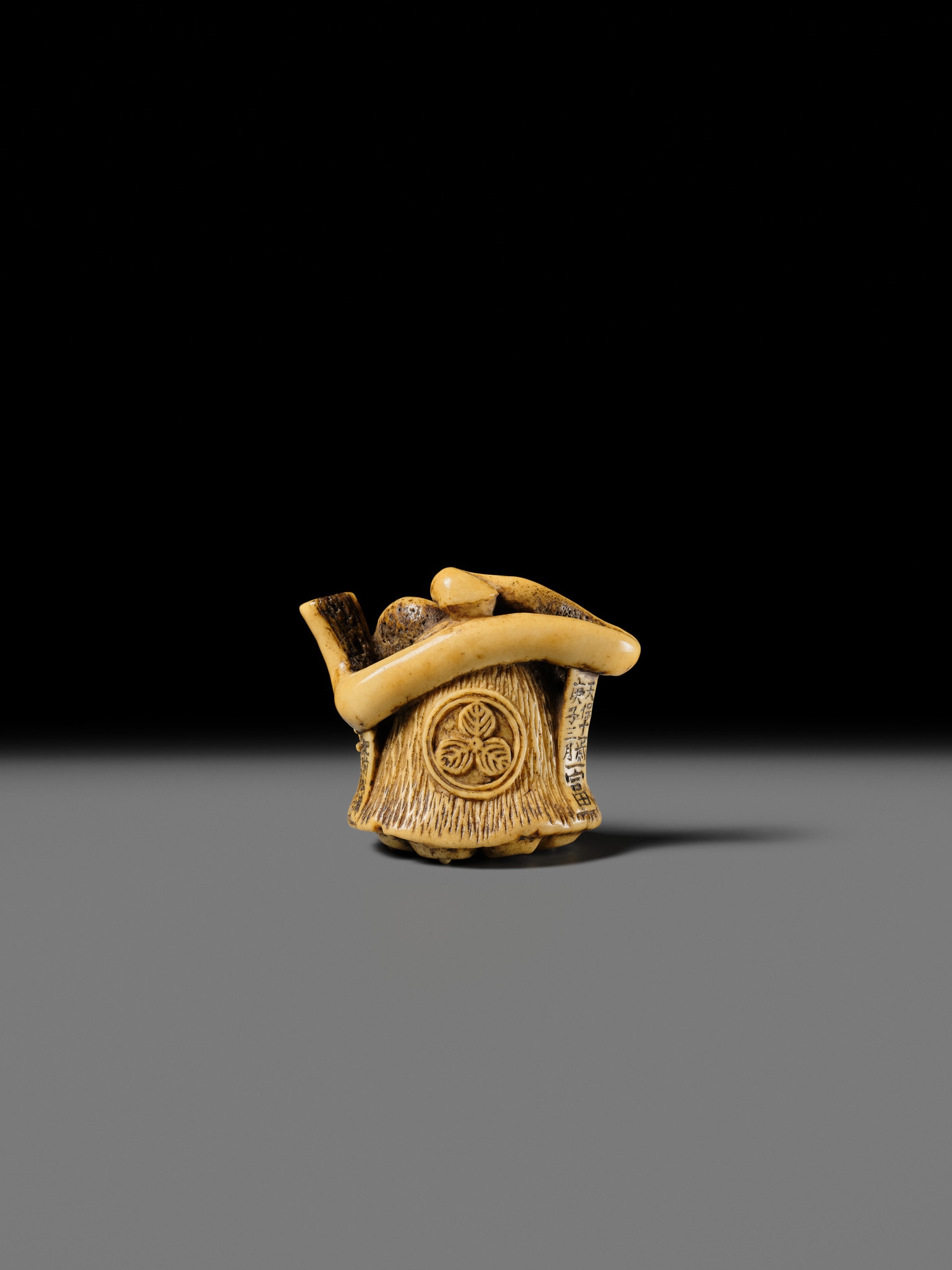 Artwork by Hizen Matsura Ittei, ITTEI: AN ANTLER (TRICK) NETSUKE OF A LOTUS POD WITH THE MAKINO CLAN MON, Made of plaque