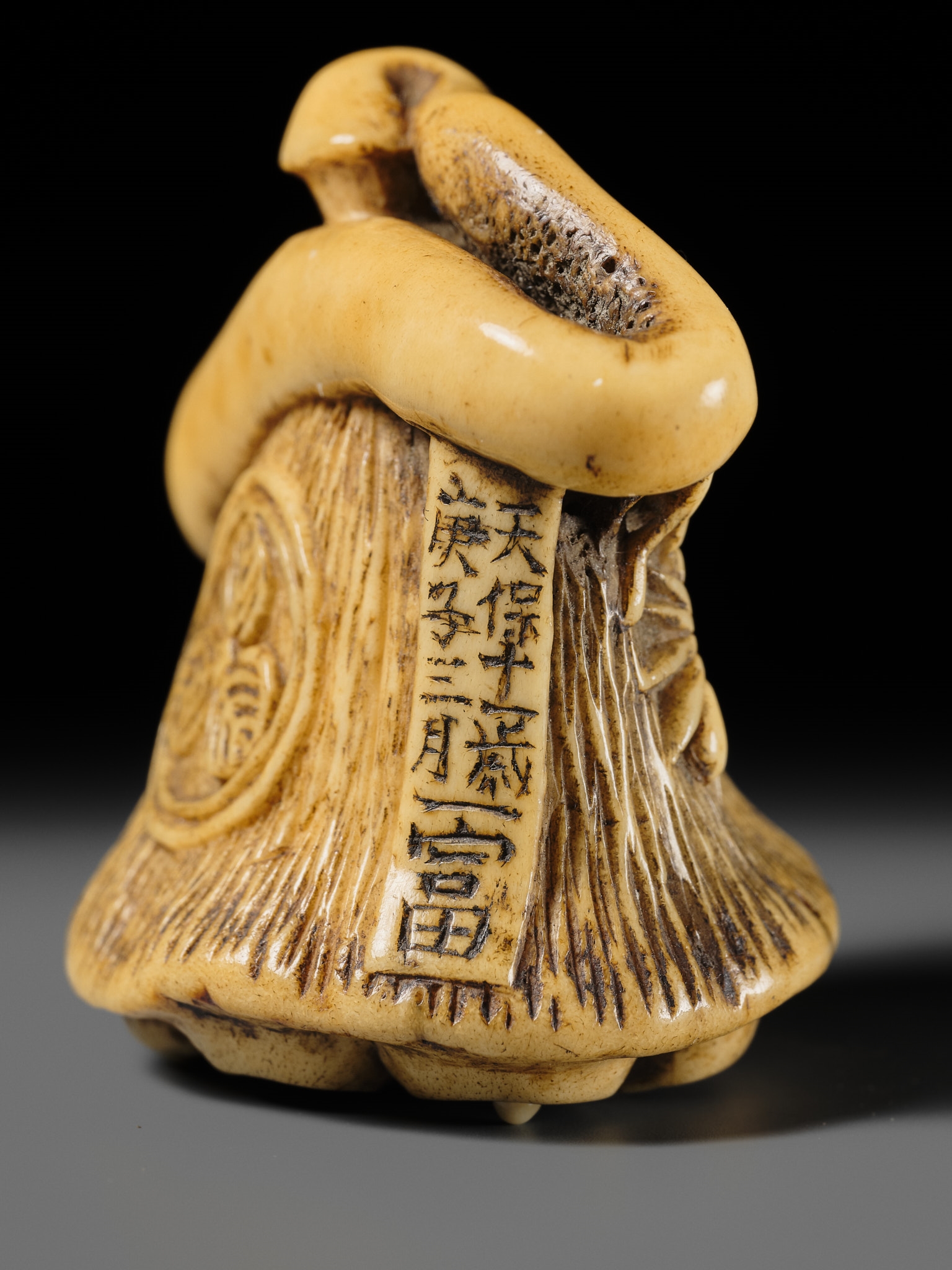 Artwork by Hizen Matsura Ittei, ITTEI: AN ANTLER (TRICK) NETSUKE OF A LOTUS POD WITH THE MAKINO CLAN MON, Made of plaque