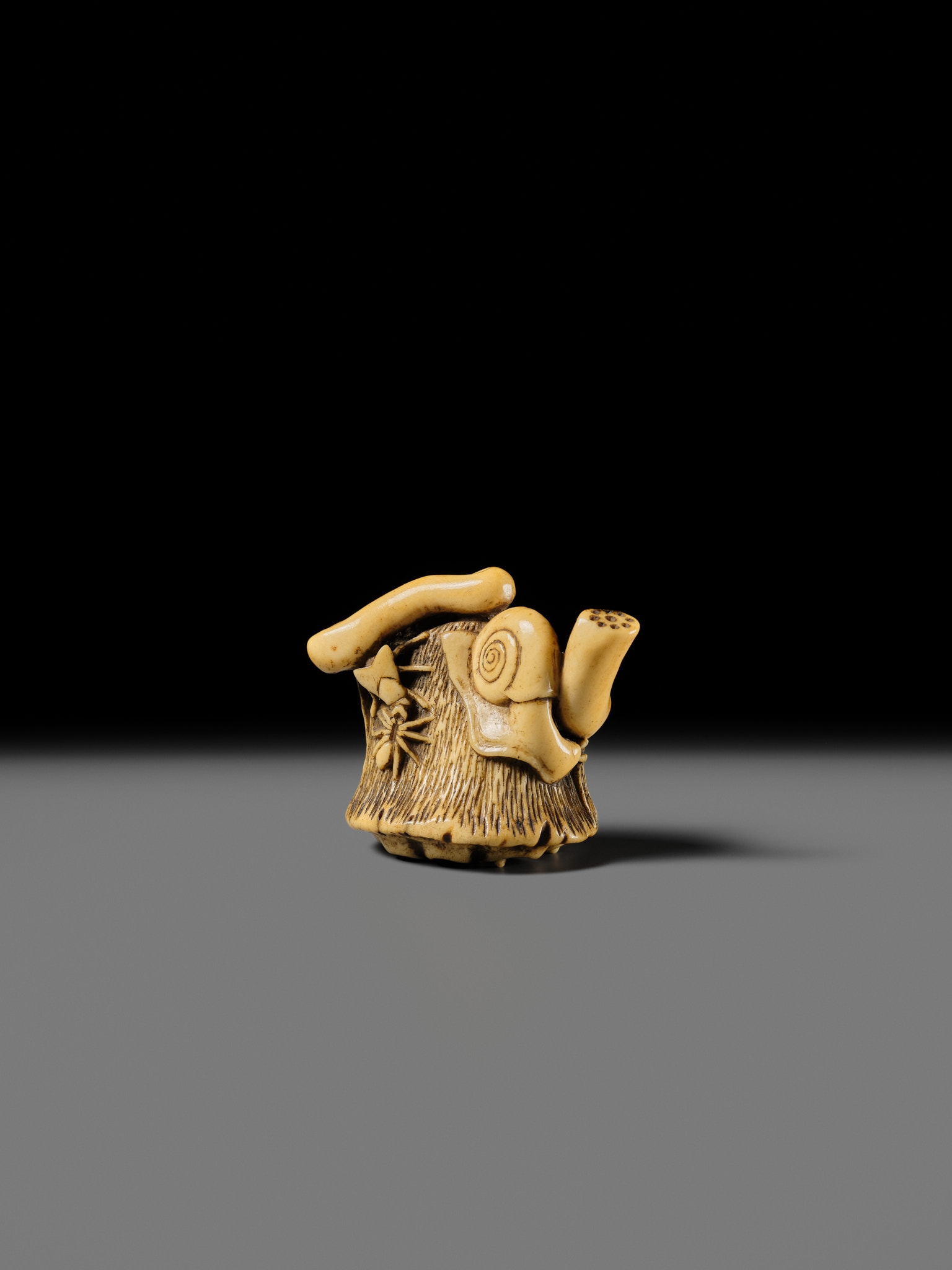 Artwork by Hizen Matsura Ittei, ITTEI: AN ANTLER (TRICK) NETSUKE OF A LOTUS POD WITH THE MAKINO CLAN MON, Made of plaque