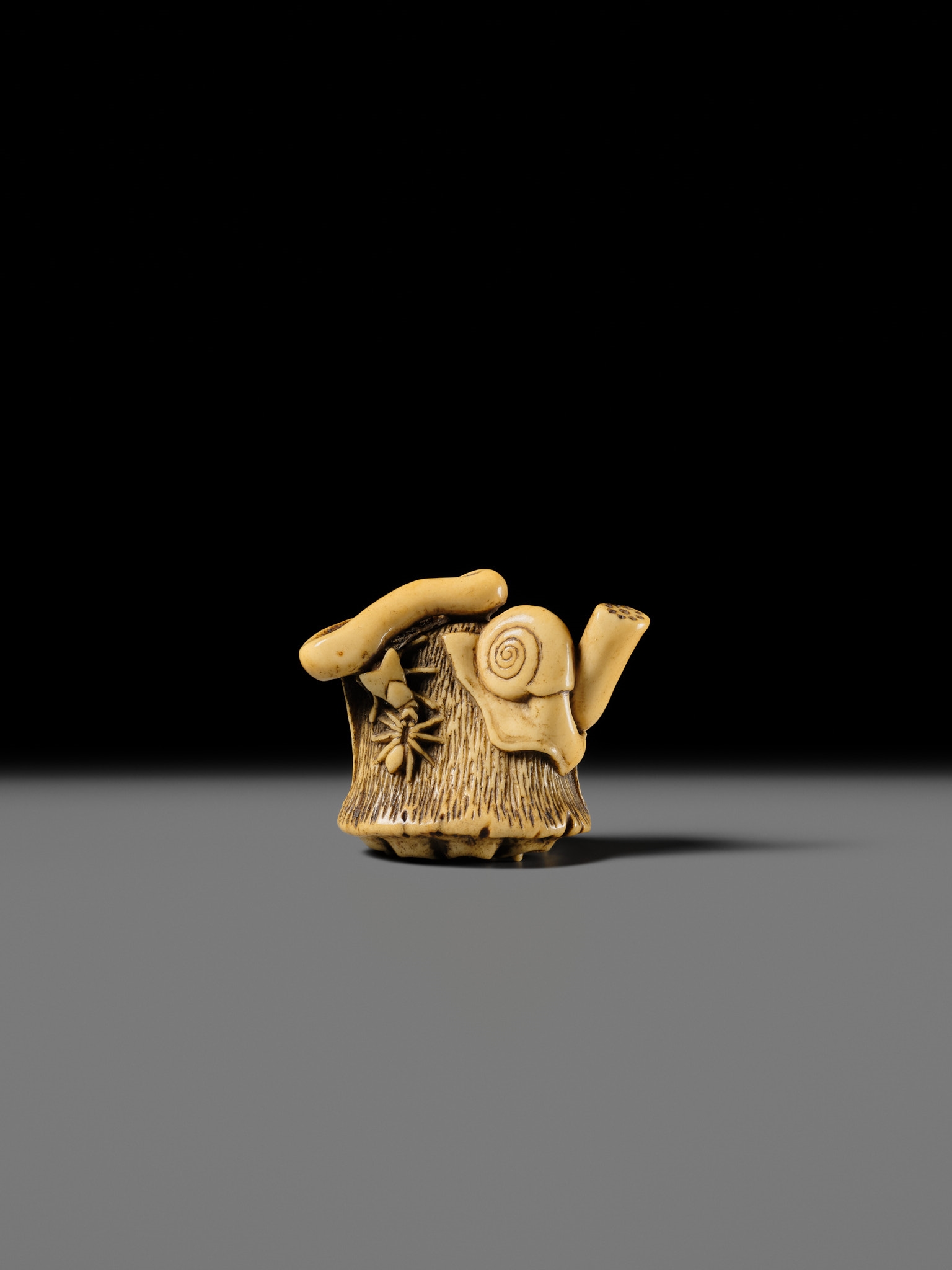 Artwork by Hizen Matsura Ittei, ITTEI: AN ANTLER (TRICK) NETSUKE OF A LOTUS POD WITH THE MAKINO CLAN MON, Made of plaque