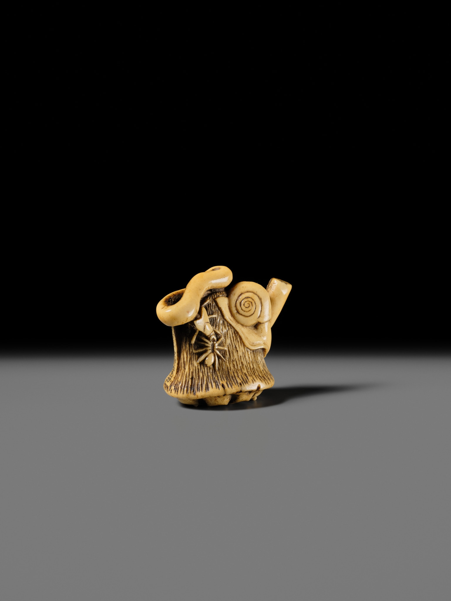 Artwork by Hizen Matsura Ittei, ITTEI: AN ANTLER (TRICK) NETSUKE OF A LOTUS POD WITH THE MAKINO CLAN MON, Made of plaque