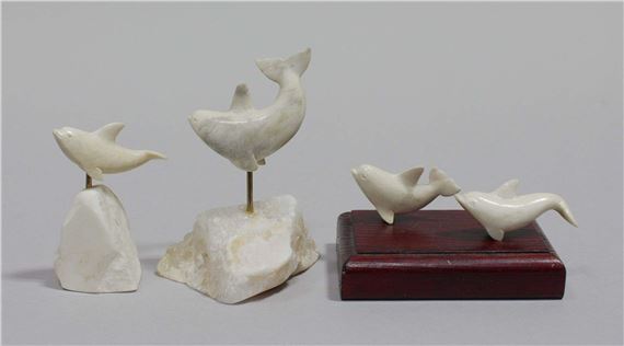 Assembled grouping of carved marine ivory figures, two mounted to a wooden platform and two mounted to natural stone