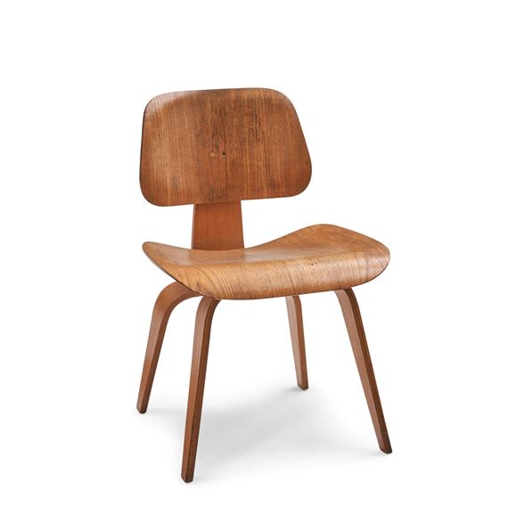 A minimalist wooden chair with a curved seat and tapered legs set against a stark white background.