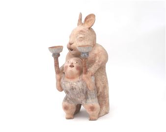 A ceramic statue of a boy with a rabbit - Heidi Daamen