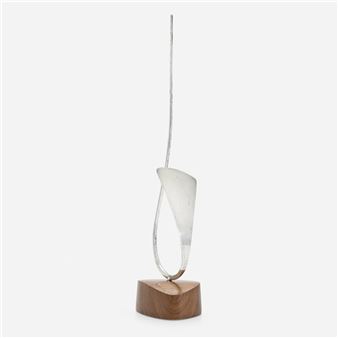 A minimalist sculpture featuring a twisted metallic form resting on a wooden base.