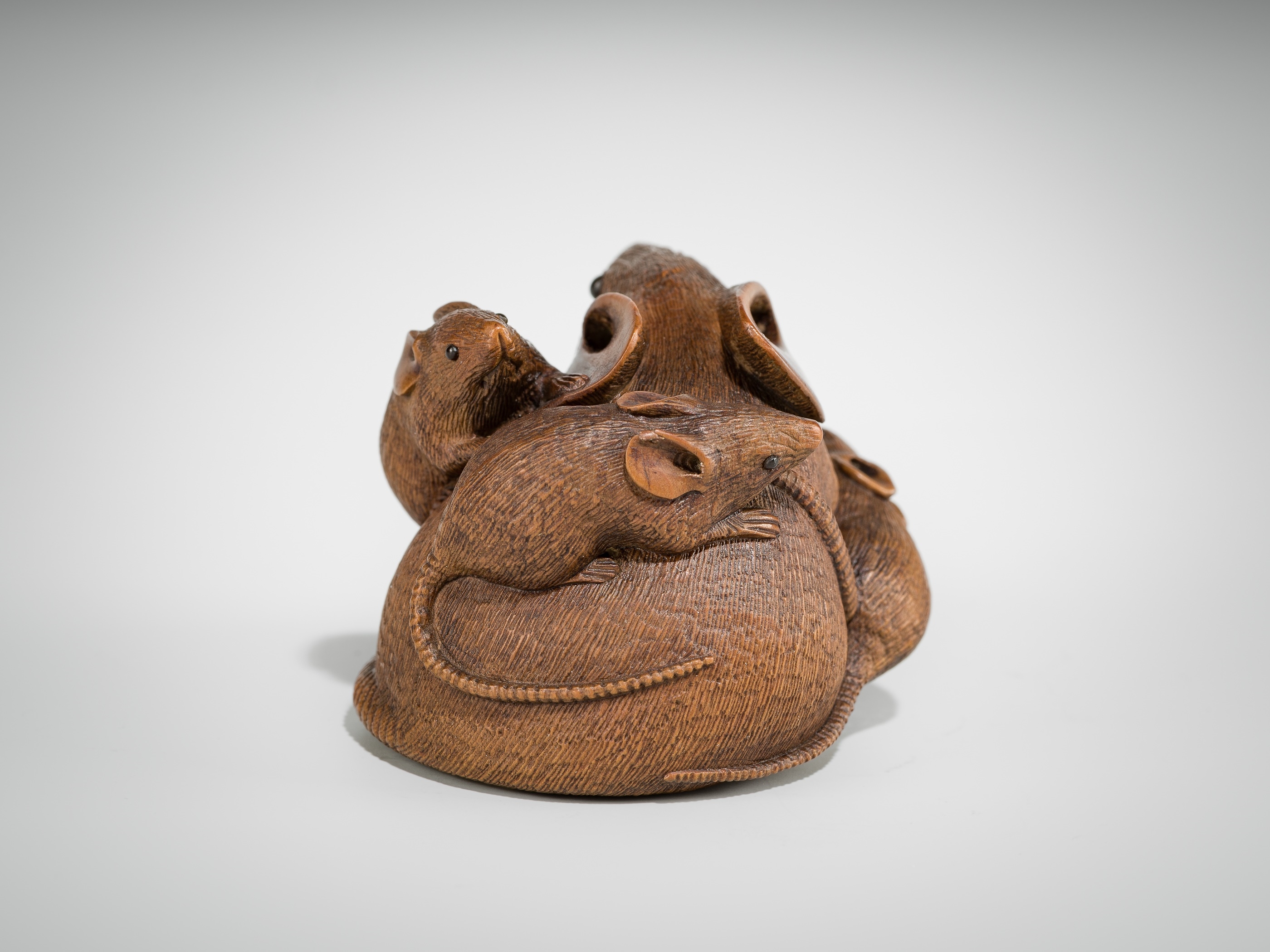 Artwork by Hokyudo Itsumin, ITSUMIN: A FINE WOOD NETSUKE OKIMONO OF A GROUP OF RATS WITH PERSIMMON, Made of wood